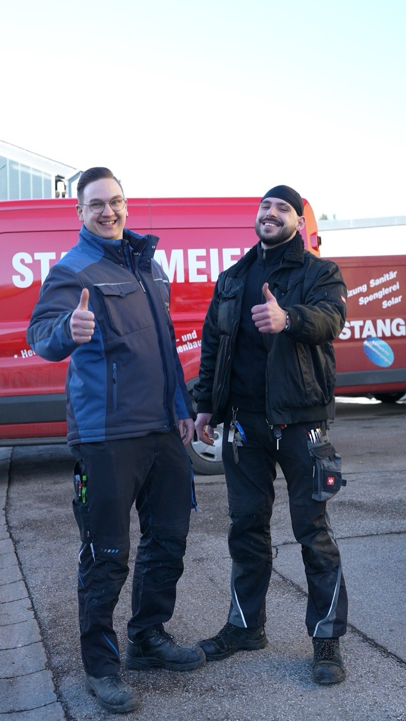 Zwei Monteure vor dem roten Firmentransporter, beide Daumen hoch