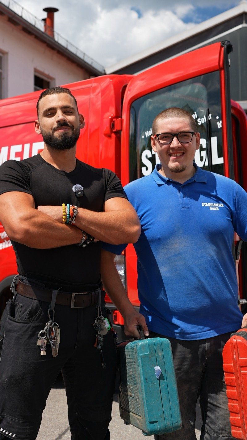 Zwei Kollegen vor dem roten Firmentransporter